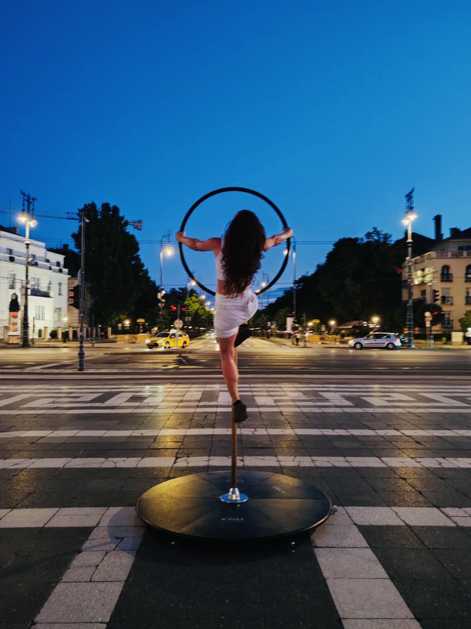 Rúdtáncos Budapest panorámájával a háttérben, naplementében