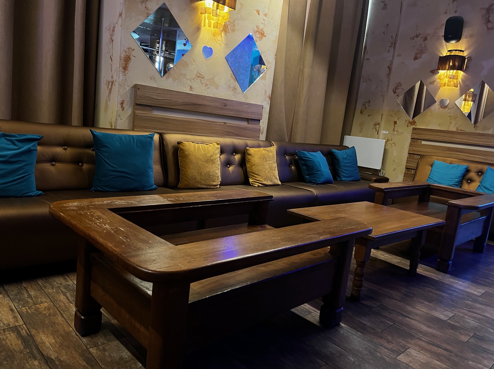 A Marilyn Night Club elegáns belső tere bőr ülőgarnitúrával, türkiz és arany párnákkal, masszív faasztalokkal